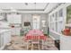 Charming dining area features a red and white checkered tablecloth and white chairs at 813 Old Windsor Way, Spring Hill, FL 34609