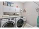 Laundry room with washer, dryer, and overhead cabinets at 813 Old Windsor Way, Spring Hill, FL 34609