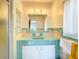 Retro bathroom with light green tile and glass shelves at 8701 Gulf Blvd, St Pete Beach, FL 33706