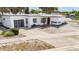 Front view of a single story home with a large driveway and landscaping at 8701 Gulf Blvd, St Pete Beach, FL 33706