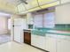 Kitchen with white cabinets and teal tile at 8701 Gulf Blvd, St Pete Beach, FL 33706