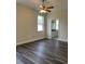 Spacious bedroom with wood-look floors, ceiling fan, and bathroom view at 1652 Open Field Loop, Brandon, FL 33510