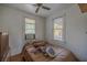 Cozy bedroom with two windows, ceiling fan, and hardwood floors at 11317 Salina St, Brooksville, FL 34614