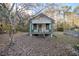 Charming white cottage with a green porch, surrounded by trees at 11317 Salina St, Brooksville, FL 34614