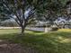 Backyard with large tree and white vinyl fence at 1700 Curry Trl # 35, North Venice, FL 34275