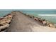 Stone jetty leading to the ocean with waves crashing gently at 1700 Curry Trl # 35, North Venice, FL 34275