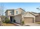Two-story house with beige exterior, two-car garage, and landscaping at 10710 Southern Forest Dr, Riverview, FL 33578