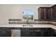 Modern kitchen features dark cabinets, quartz countertops, and stainless steel appliances at 10710 Southern Forest Dr, Riverview, FL 33578
