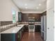 Modern kitchen with dark cabinets, stainless steel appliances, and quartz countertops at 10710 Southern Forest Dr, Riverview, FL 33578
