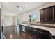 Open kitchen boasts dark cabinetry, quartz countertops, and stainless steel dishwasher at 10710 Southern Forest Dr, Riverview, FL 33578