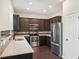 Modern kitchen with dark cabinets, stainless steel appliances, and quartz countertops at 10710 Southern Forest Dr, Riverview, FL 33578