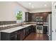 Modern kitchen with dark cabinets, stainless steel appliances, and quartz countertops at 10710 Southern Forest Dr, Riverview, FL 33578
