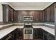 Modern kitchen with dark cabinets, stainless steel appliances, and quartz countertops at 10710 Southern Forest Dr, Riverview, FL 33578