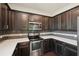 Modern kitchen with dark cabinets, stainless steel appliances, and quartz countertops at 10710 Southern Forest Dr, Riverview, FL 33578