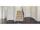 Modern staircase with dark wood railing and neutral carpeting at 10710 Southern Forest Dr, Riverview, FL 33578