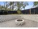 Fire pit in paved backyard with retaining wall and privacy fence at 12631 Timber Run, Dade City, FL 33525