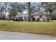 Brick home with a tree-lined front yard and street view at 12631 Timber Run, Dade City, FL 33525