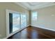 Bedroom with hardwood floors, balcony access and water views at 13737 Victor Ave, Hudson, FL 34667