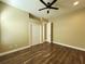 Bright bedroom with wood floors, ceiling fan, and double door closet at 13737 Victor Ave, Hudson, FL 34667