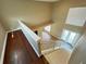 Upstairs hallway view of staircase, hardwood floors, and living area at 13737 Victor Ave, Hudson, FL 34667