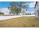 Grass backyard with a privacy fence and large oak tree at 27096 Wakefield Dr, Brooksville, FL 34602