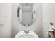 Small bathroom with an oval mirror, white sink, and toilet at 27096 Wakefield Dr, Brooksville, FL 34602