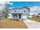 Newly built two-story home with gray siding, a porch, and a driveway at 27096 Wakefield Dr, Brooksville, FL 34602