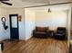 Living room with brown leather recliner and sofa, laminate wood floors at 7301 Anacapa Ln, Plant City, FL 33565