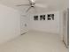 Bright bedroom featuring three windows, a ceiling fan, white painted floors, and a convenient closet for ample storage at 112 Nippino W Trl, Nokomis, FL 34275