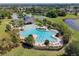 Community pool with clubhouse and surrounding landscaping at 13752 Reindeer Cir, Hudson, FL 34669