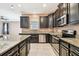 Kitchen with dark cabinetry, granite countertops, and stainless steel appliances at 13752 Reindeer Cir, Hudson, FL 34669