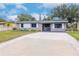 Gray house with white shutters, gravel driveway, and small front yard at 4760 84Th N Ter, Pinellas Park, FL 33781