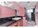 Pink bathroom with black granite vanity and walk-in shower at 8280 140Th St, Seminole, FL 33776