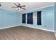 Blue bedroom with wood-look flooring and ceiling fan at 8280 140Th St, Seminole, FL 33776