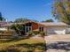 Brick ranch home with landscaped yard, attached garage, and walkway at 8280 140Th St, Seminole, FL 33776