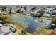 Aerial view showcasing a pond with lily pads and houses in a residential community at 7644 Arlight Dr, New Port Richey, FL 34655