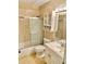 Bathroom with a shower and glass door, a toilet, a sink, and a cabinet above the toilet at 7644 Arlight Dr, New Port Richey, FL 34655