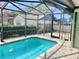 Inviting screened-in pool area with brick pavers, and view of the backyard at 7644 Arlight Dr, New Port Richey, FL 34655