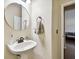 Stylish half bathroom with pedestal sink, round mirror, and elegant fixtures at 11143 Rising Mist Blvd, Riverview, FL 33578