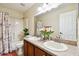 Bathroom featuring double sinks, neutral countertops, decorative flowers, and a shower-tub combo at 11143 Rising Mist Blvd, Riverview, FL 33578