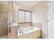 Bathroom featuring a large tub with tile surround and a window with blinds at 11143 Rising Mist Blvd, Riverview, FL 33578