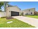 Charming two-story home with gray stucco exterior, dark garage door, and lush landscaping at 11143 Rising Mist Blvd, Riverview, FL 33578