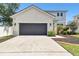 Charming two-story home with gray stucco exterior, dark garage door, and lush landscaping at 11143 Rising Mist Blvd, Riverview, FL 33578