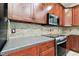 A kitchen area showcases the mosaic backsplash with tile, granite countertops, and stainless steel oven range at 11143 Rising Mist Blvd, Riverview, FL 33578