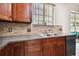 Kitchen with granite countertop, stainless steel dishwasher, and tiled backsplash complemented by wooden cabinets at 11143 Rising Mist Blvd, Riverview, FL 33578