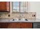 Kitchen sink features a stainless steel double sink, granite countertops, and a mosaic tile backsplash at 11143 Rising Mist Blvd, Riverview, FL 33578