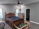 Bedroom with gray walls, a ceiling fan, wooden floors, and a door leading to another room at 12707 Blue Pine Cir, Hudson, FL 34669