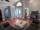 Bright living room featuring tile floors, a chandelier, and a large window above the front door at 12707 Blue Pine Cir, Hudson, FL 34669