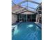 Refreshing in-ground pool with screened enclosure, perfect for outdoor enjoyment and relaxation at 12707 Blue Pine Cir, Hudson, FL 34669