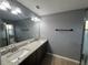 Main bathroom featuring double sinks, granite countertop, a walk-in shower and wood look flooring at 13193 Paxton Ave, Weeki Wachee, FL 34614